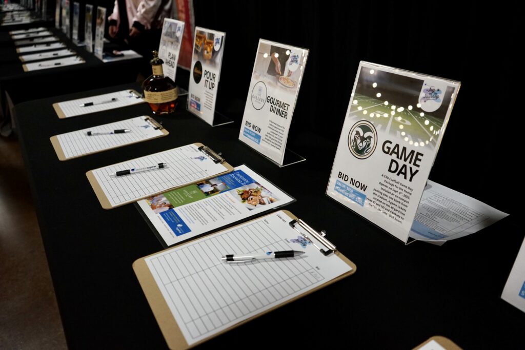 Silent auction table with sign up sheets for bidding